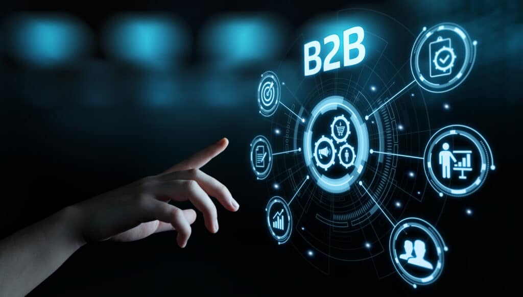 A hand pointing toward a holographic B2B marketing flowchart with various icons representing business processes.